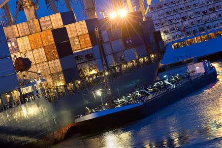补给船加油停泊在商业港口的一艘大型集装箱船舶上和倾斜工业的旁边图片