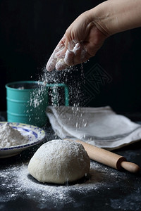 面粉包和比萨饼用黑底的面粉做糕点小麦烹饪图片