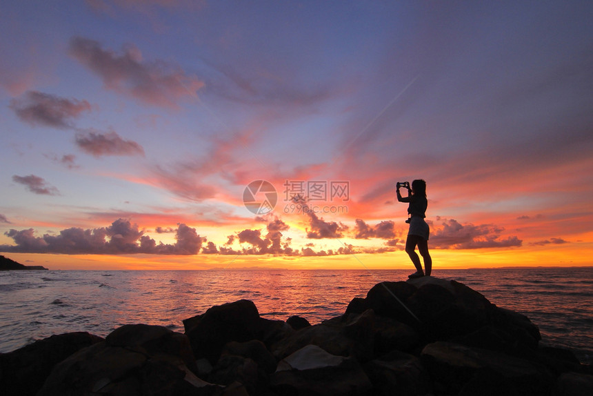 女士人们在海滩上拍照的美丽天空背景中女轮廓假期图片