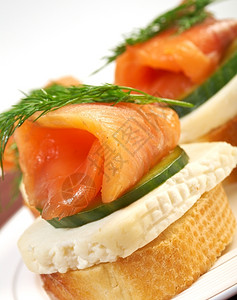 开胃菜黑胡椒含烟熏鲑鱼奶酪和黄瓜的甘蔗食物图片