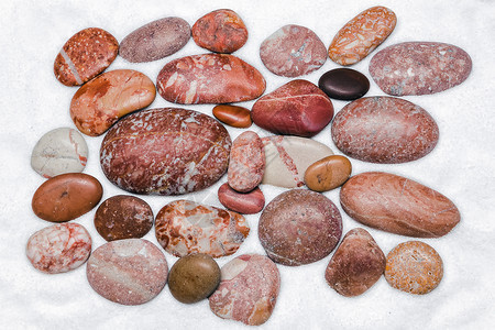 红色的白各种红颜石块紧贴白沙上色背景的彩石块棕图片