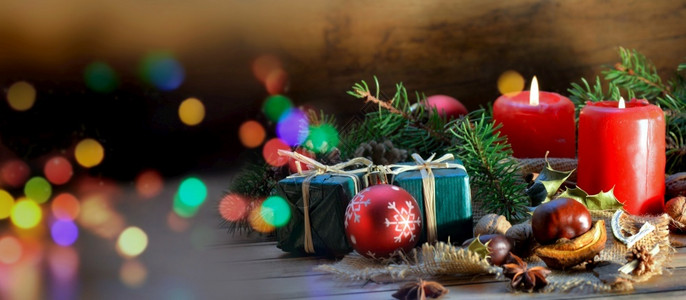 一种丰富多彩的木桌和模糊灯光上传统圣诞节装饰品蜡烛假期高清图片素材
