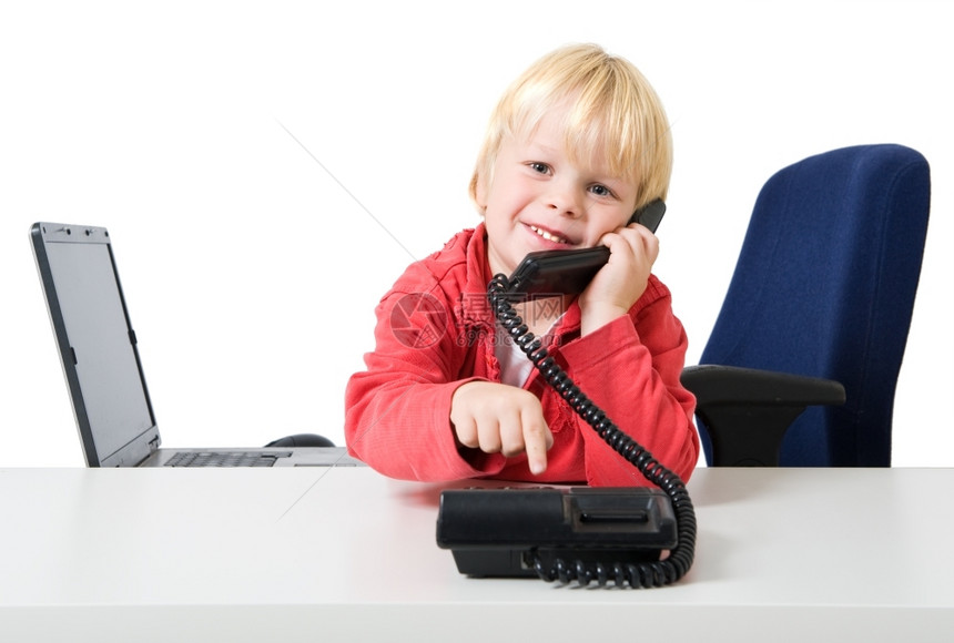 穿着红色毛衣的金发年轻男孩在Sparce办公室电话拨号微笑露齿的红色图片