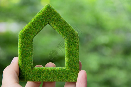 绿色房屋图标概念保持手花园背景图片