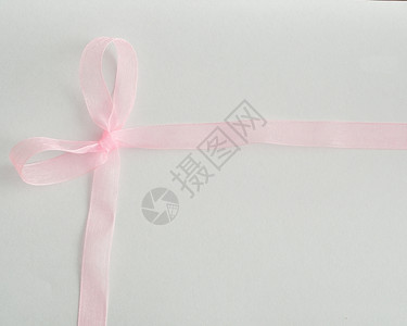 生日一条丝绸带绑在白底的蝴蝶结上天丝滑背景图片