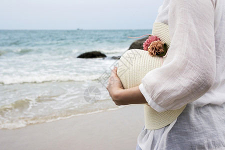 沙滩上戴帽子的女人图片