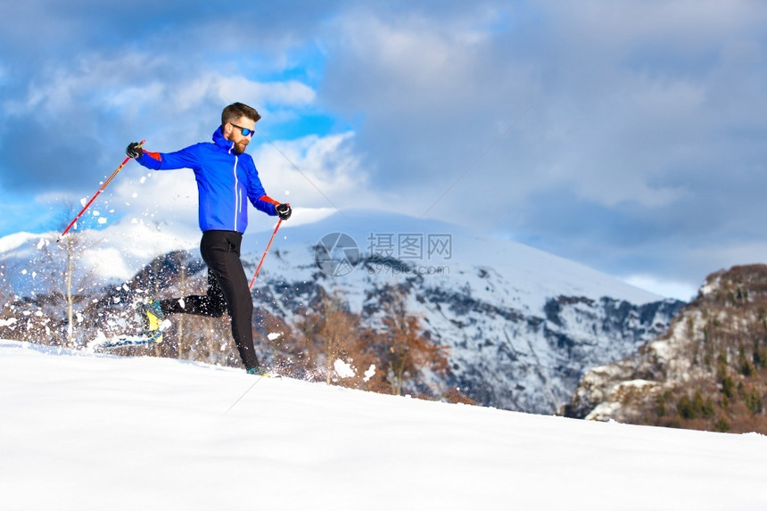 一个带着雪鞋下山的男人一种运动雪鞋行走图片