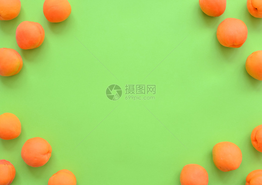 夏天绿背景的杏子排列在角落框中带复制空间顶视图关闭绿色背景的水果架子在角上安排复制空间顶视图关闭面板最佳黄色的图片