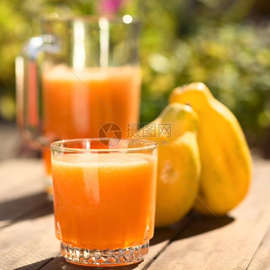一杯新鲜制备的木瓜汁后面放着水罐和木瓜果放在户外桌子上选择聚焦在玻璃的前面新鲜重点喝图片