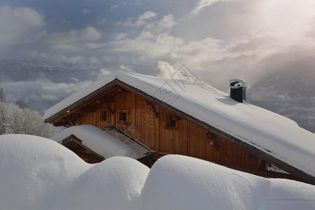 霜高山村庄的木制小屋覆盖着山地新雪风景优美寒冷的图片