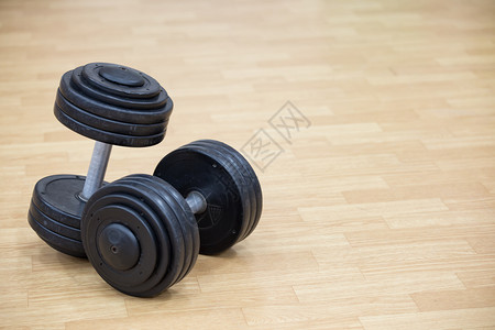 体育和哑铃在健身背景馆地板上打哑铃运动主题的背景为吹哑铃运动主题肌肉发达健康建造背景图片