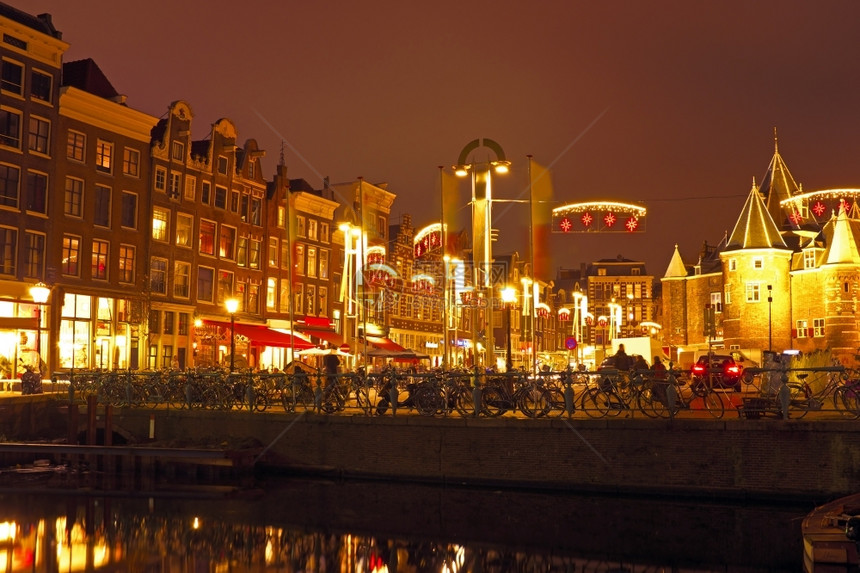 公共交通灯晚上在荷兰阿姆斯特丹与瓦格大楼同在桥图片