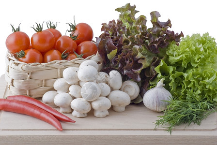 红色的新鲜有机蔬菜沙拉番茄红胡椒蘑菇大蒜和菜放在切碎板上图片