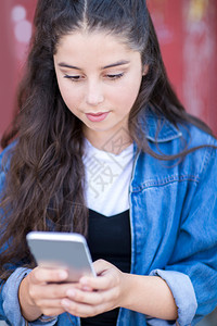 老的城市环境中在移动电话上发短信的青少年女孩消息传递肩膀图片