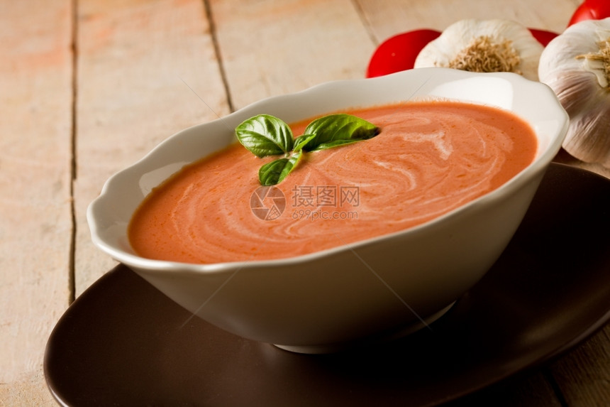 可口牛奶樱桃木桌上的番茄奶油汤与大蒜和巴锡图片