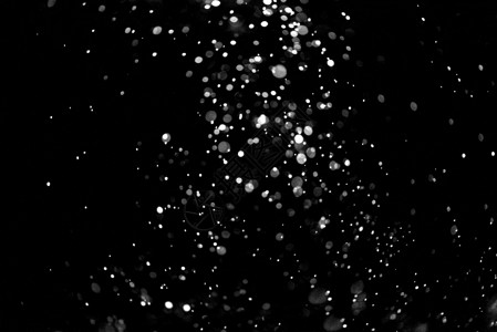 在黑色背景上飘落的雪花在黑色背景上飘落的雪花圣诞节明亮的质地图片