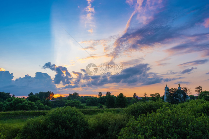 美观的明云全景在日落的光芒中和白教堂的钟塔俄罗斯橙夏天蓝色的图片