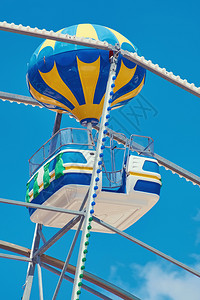 娱乐夏天Ferris轮子座椅在蓝天飞轮子座上旋转图片