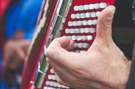玩民谣节的手风琴上低音键手指细节艺术家日图片
