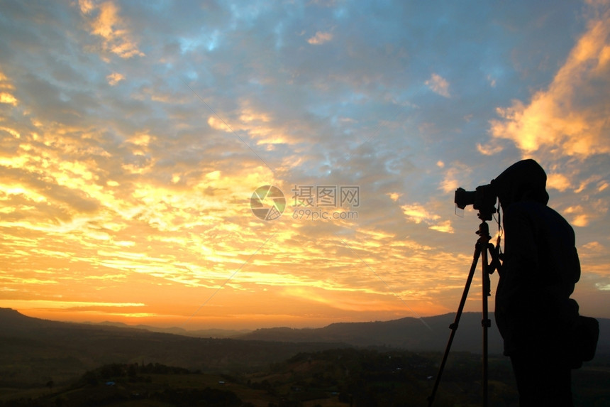 山专业的男人摄影师拍美丽日出照片的影轮廓图图片