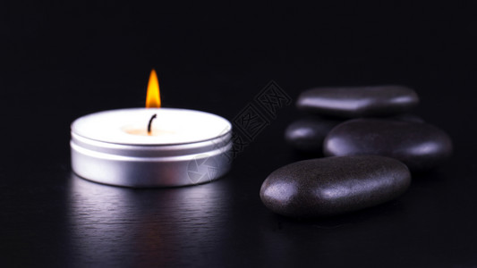 辉光黑宝石和背景蜡烛的近缝温暖泉图片
