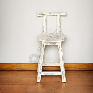 面对平墙背景的石制白色木板凳的空椅子高清图片