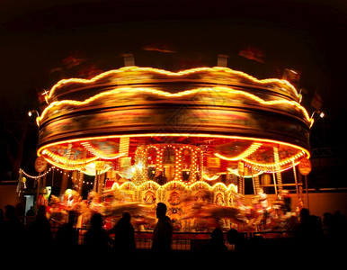 丰富多彩的旋转木轮灯在游乐公园运动旋转木轮灯在夜间圆形的车轮图片