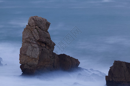 黄昏西班牙坎塔布里亚州连克斯阿尔尼亚海滩的岩石许可证结图片