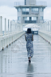 悲哀单身妇女带着雨伞和水在路上行走孤独背部图片