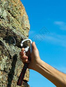 卡宾和钩在石头上的绳子登山扣活动图片