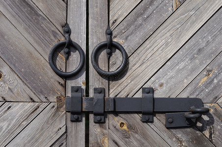 乡村关闭旧木门用两个黑铁环和螺栓锁定木板图片