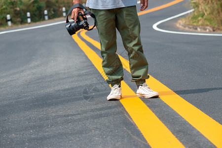 自然保持摄影师手里拿着照相机在路上行走的摄影记者美丽图片
