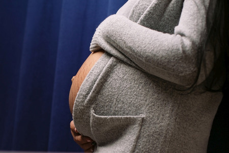 母亲期待美丽的年轻孕妇在蓝色背景婴儿等待概念下抚摸肚子的婴儿等候概念图片