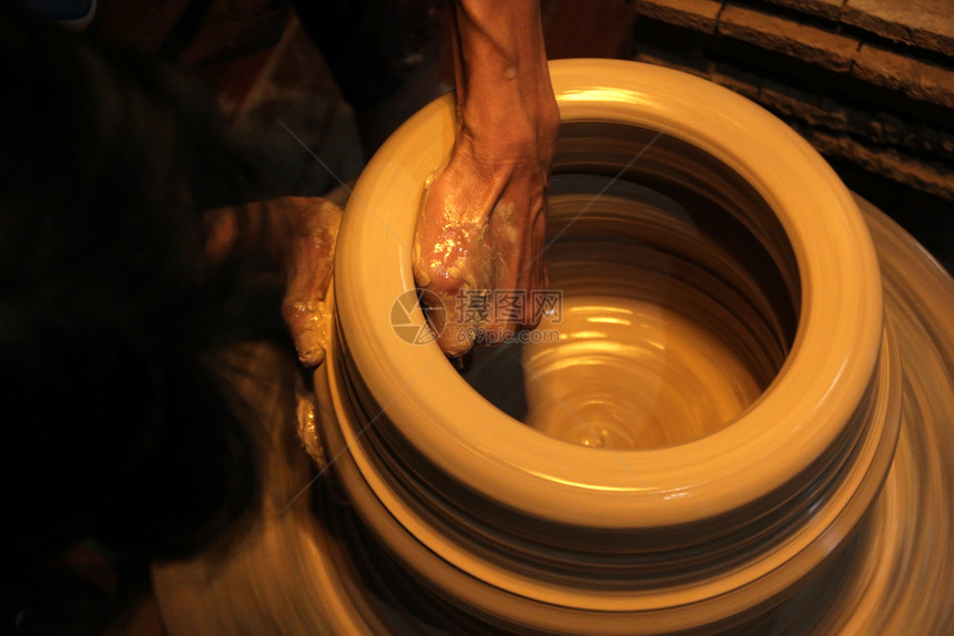 紧双手在陶器轮上做波特工艺餐具图片