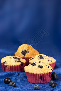 甜点成熟蓝色织物背景上的自制蓝莓松饼蛋糕图片