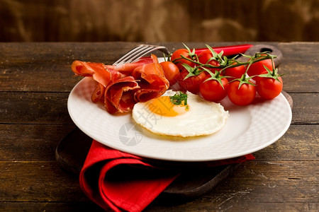 篮子香料英国早餐煎蛋和木制桌上培根的概念照片在木制桌上图片
