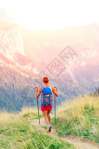 徒步旅行女士孤独山上登和北欧徒步拐杖的妇女远足者图片