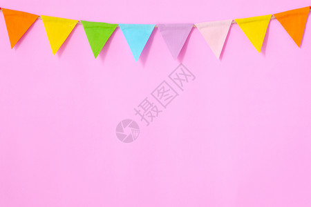 懒政三角形节日挂在粉红背景生日周年纪念庆祝活动贺卡背景的彩色政帜贴在花上粉色的设计图片