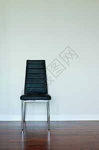 内部的装饰风格自在空白墙上的黑皮椅图片