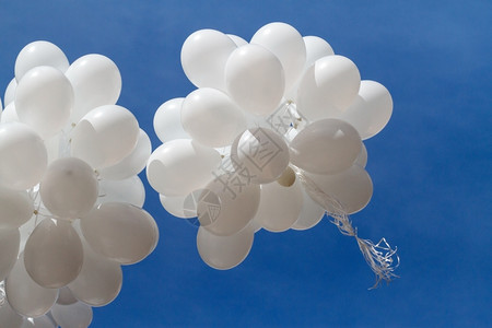 乳胶白气球对天上一堆白色气球飞向蓝天空云彩闪耀团体浪漫的背景图片