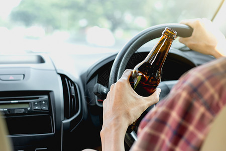 青年游客在喝酒时开车驾驶危险的啤酒图片