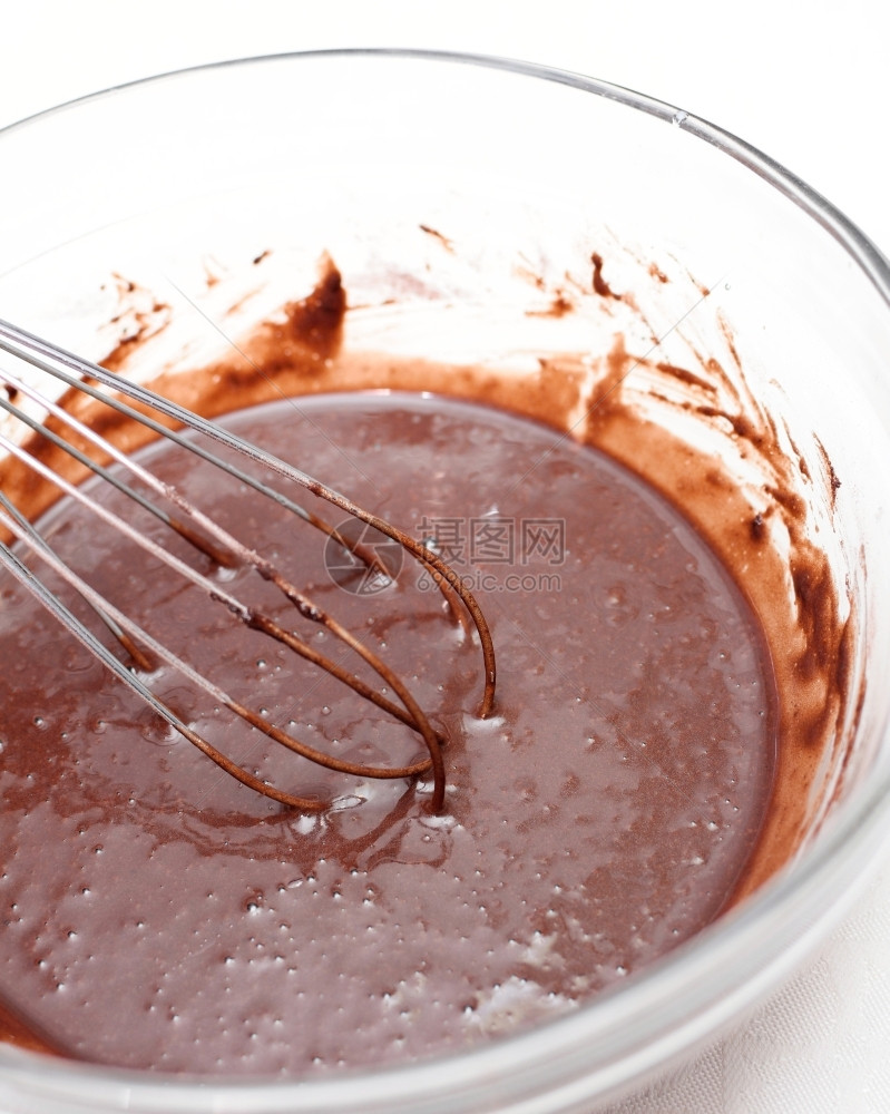 搅拌混合把巧克力面团混在玻璃碗里做蛋糕的可图片