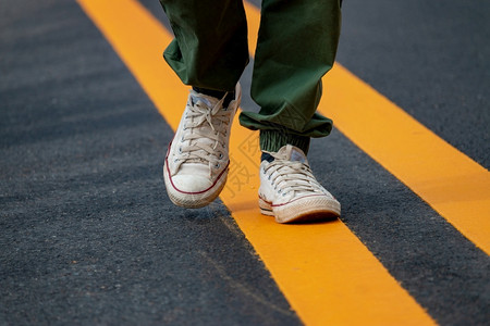 鞋类黑色的女士穿着运动鞋的男子在街上走着黄线图片
