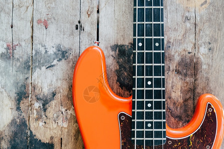 字符串木背景和复制空间的橙色电贝须吉他旋律木头图片