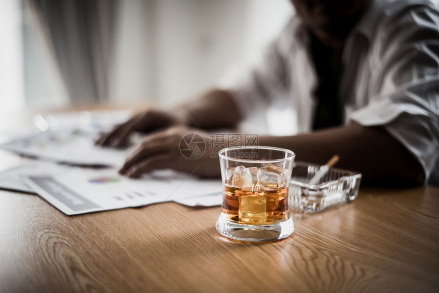 商人在工作场所因紧张而饮酒压力威士忌沮丧的图片
