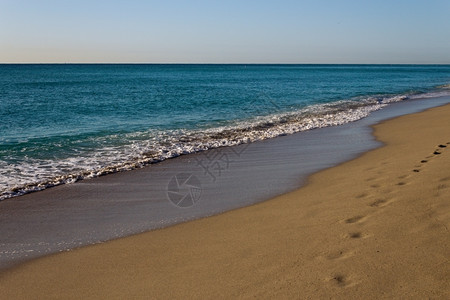 海景滩潮水在金沙上滚落阳光背景图片