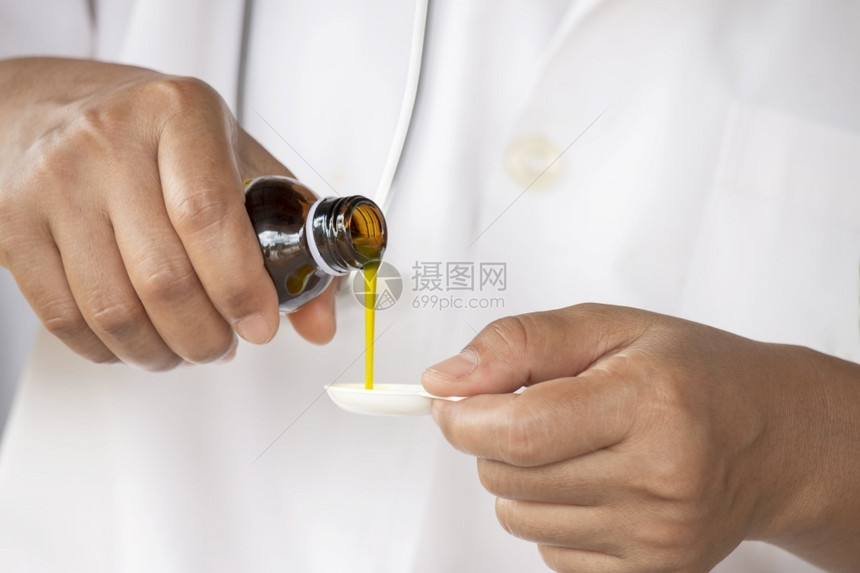 液体将糖浆药品倒入清勺子的医务人员之手测量关心图片
