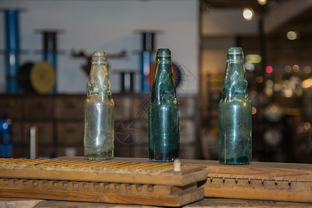 瓶子饮料用过的木板上三个绿色空和脏玻璃瓶木板上三个绿色空和脏玻璃瓶图片