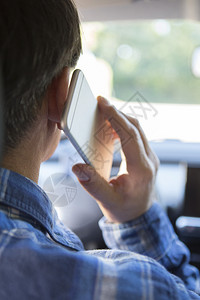 粗心在汽车里谈论移动电话时驾驶的男人分心垂直的图片
