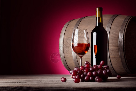 食物香槟酒一杯红瓶子和葡萄放在红底的酒一杯瓶子和葡萄图片
